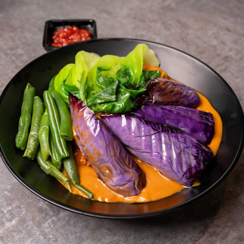 Filipino dish with green beans, purple eggplant, and lettuce in a rich orange sauce, with chili on the side.
